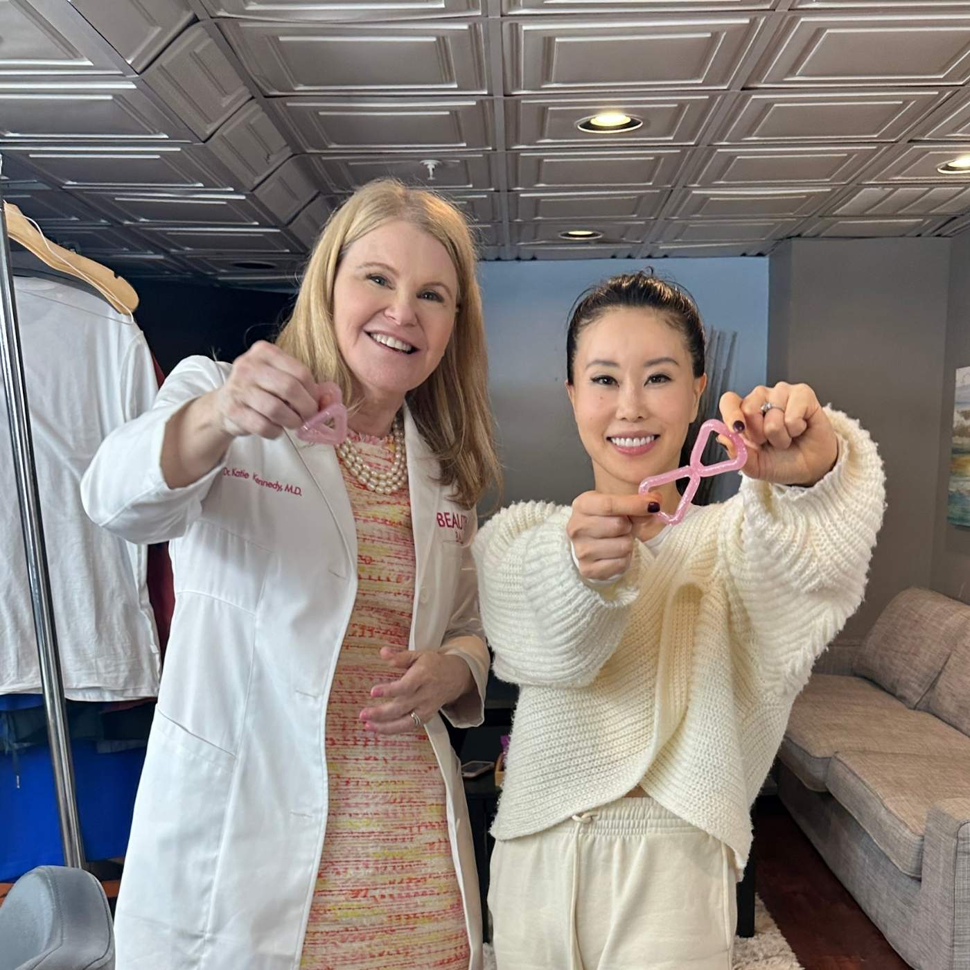 Dr. Katie and Koko from Face Yoga holding the Triangle and Butterfly tools — combining clinical design with natural facial exercise methods for lift, balance, and airway support.