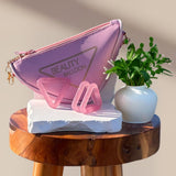 Pink Triangle and Butterfly tools with the Beauty Balloon pouch on a wooden stool — doctor-designed facial and neck strengthening system that supports lift, tone, jaw relaxation, and improved nightly breathing.